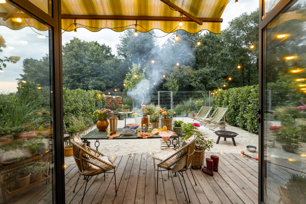 Outdoor patio with seating area, firepit, and ambient lighting