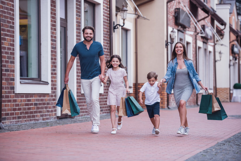 A vibrant community with nearby shops, a cafe, and families enjoying a local park